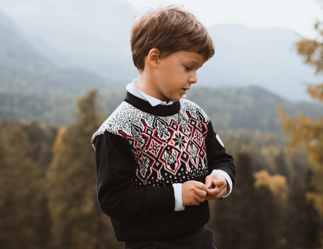Kid wearing a wool holiday sweater from Dale of Norway outside
